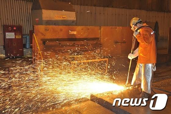 폭염이 기승을 부리는 가운데 16일 포스코 광양제철소(소장 안동일) 제강부 연주공장에서 한 직원이 7∼800도 가량 되는 뜨거운 슬라브 위에서 방열복을 입고 불꽃을 튀기며 스카핑(Scarfing) 작업을 하고 있다.(광양제철소 제공) © News1 서순규 기자