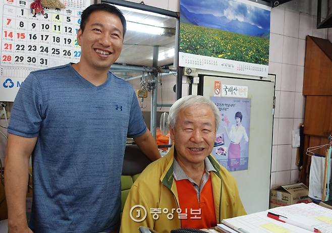 팔판정육점 2대와 3대를 잇는 이경수·준용(왼쪽)씨 부자가 집무실이라 할 수 있는 책상 앞에 나란히 자리했다. 수십 년 써온 출납장부 앞에서 웃는 표정은 순조로운 대물림을 보여주는 듯하다.