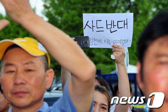 21일 오후 성주군청 앞에서 김천에서 온 한 주민이 '사드 반대'라고 적힌 종이를 들고 시위를 벌이고 있다.  2016.8.21/뉴스1 © News1 이종현 기자