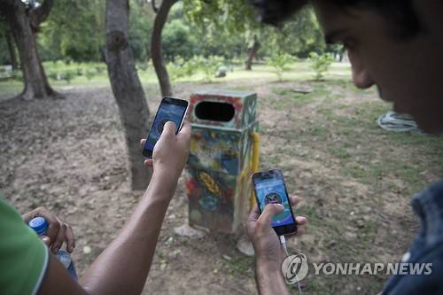 지난 7월 22일 인도 뉴델리 로디가든 공원에서 젊은이들이 스마트폰으로 포켓몬고 게임을 하고 있다.[AP=연합뉴스 자료사진]