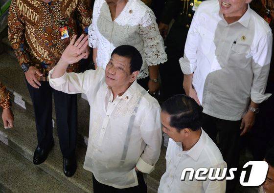 인도네시아를 방문중인 로드리고 두테르테 필리핀 대통령(앞줄 왼쪽)이 9일(현지시간) 조코 위도도 인도네시아 대통령과 함께 자카라트 타나아방 시장을 방문했다. © AFP=뉴스1