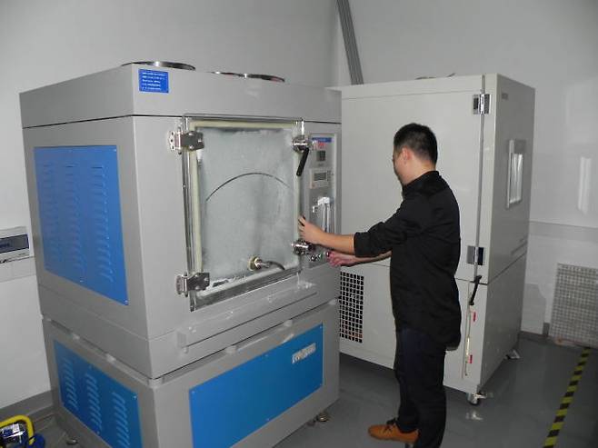 방진 기능 측정하는 기기를 KTL 중국 시험소 직원이 살펴보고 있다.