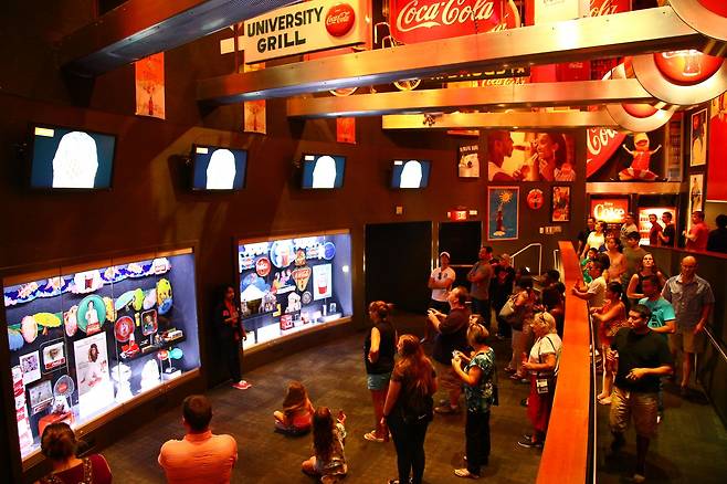 월드 오브 코카콜라를 찾은 관람객들이 코카콜라에 대한 설명을 듣고 있다.