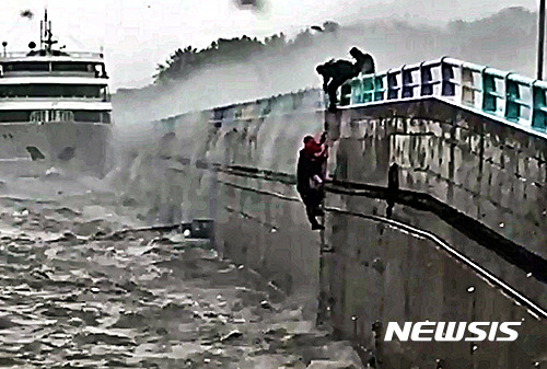 【서울=뉴시스】태풍 차바가 북상한 5일 오전 전남 여수시 덕충동 엑스포 신항부두에서 여객선이 좌초되어 승선원이 추락, 여수해경 122구조대가 구조활동을 펼치고 있다. 2016.10.05. (사진=국민안전처 제공)    photo@newsis.com