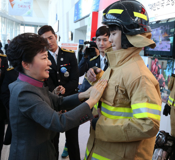 박근혜 대통령이 지난 2013년 11월12일 경기 고양시 킨텍스에서 열린 제51주년 소방의 날 기념식에서 전시관 관람을 하면서 방화복 지퍼를 올려주고  있다. /청와대사진기자단