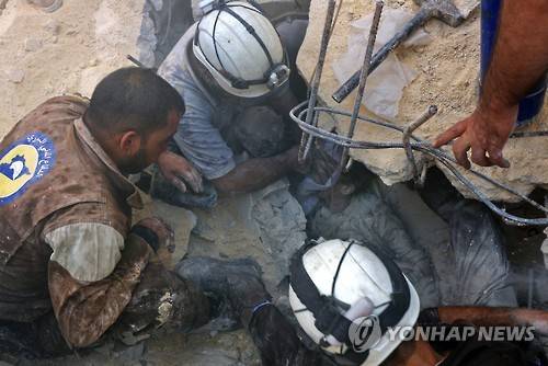 시리아 알레포 동부 반군지역에 러시아의 대대적 공습이 가해진 11일(현지시간) 민간구조대 '하얀헬멧' 대원들이 건물 잔해에 갇힌 어린이에게 산소마스크를 대고 있다. [AFP=연합뉴스]