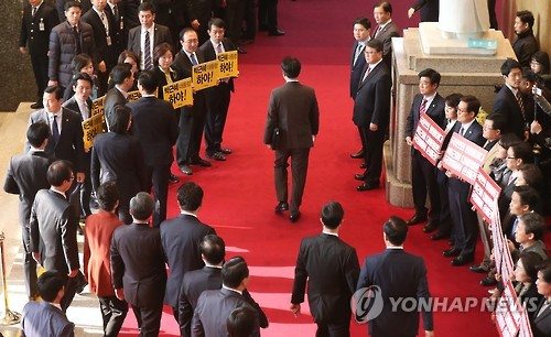 8일 오전 국회 본청에서 야당의원들이 박근혜 대통령(붉은 옷 뒷모습)의 도착에 맞춰 하야를 촉구하는 피켓을 들어 보이고 있다. / 사진=연합뉴스