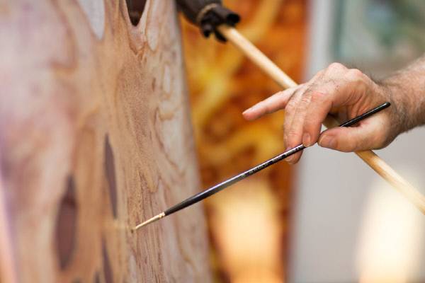 말스틱을 사용하고 있는 화가의 손.