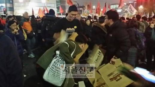 촛불집회 참가자에게 빵 10박스를 나눠준 빵집 주인 - 19일 오후 시민들과 경찰이 대치한 서울 경복궁역 사거리에서 인근 빵집 직원이 나타나 빵 10박스를 풀어 시민들에게 나누어 주었다. 빵은 단 10분 만에 동이 났다.홍인기 기자 ikik@seoul.co.kr