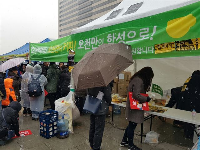 26일 오후 광화문광장에서 열린 5차 촛불집회를 앞두고 인터넷 커뮤니티 '82cook'의 회원들이 집회 참가자들에게 하야 커피를 나눠주고 있다. 박재현 기자