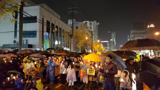 새누리당 이정현 대표의 지역구인 전남 순천시 연향동 국민은행 앞 도로에서 시민 20000여명이 모여 비오는 궂은 날씨에도 불구하고 촛불을 손에 들고 '박근혜 하야'를 외치고 있다.