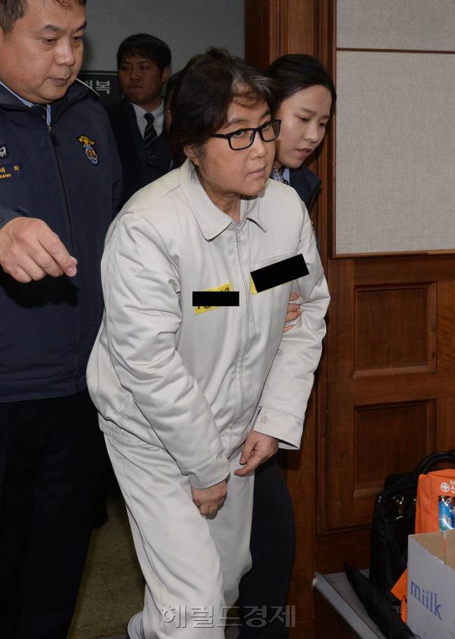 [사진설명=순실씨가 19일 오후 1시40분 서울 서초구 서울중앙지법 형사대법정에서 열린 국정농단 사건 첫 재판에 입장하고 있다. 최 씨는 이날 628번 연회색 수의에 검은 뿔테 안경을 끼고 오후 2시10분 열린 공판 준비기일에 참석했다. 준비기일에서는 검사측과 변호인간 본격 재판에 앞서 공소사실의 쟁점을 정리하고 증거조사와 증인 채택 등을 논의한다. /사진공동취재단]