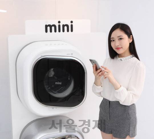 동부대우전자 모델이 사물인터넷(IoT) 기술을 적용한 벽걸이 드럼세탁기인 ‘미니(모델명 DWD-03MBLC)’ 신제품을 소개하고 있다. 동부대우전자는 IoT 기술을 적용한 첫번째 자사 가전인 미니의 출시를 시작으로 스마트폼 가전 시장에 본격 진출한다고 26일 밝혔다. 이번에 출시한 미니의 색상은 연한 은색(라이트실버)이며 가격은 50만원대이다. /사진제공=동부대우전자