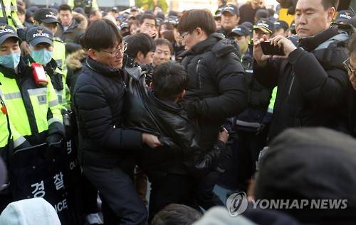 강제연행되는 소녀상 농성자 (부산=연합뉴스) 김선호 기자 = 부산 시민단체가 28일 부산 일본영사관 앞에서 기습적으로 소녀상을 설치한 가운데 구청 직원들이 소녀상에서 연좌농성을 벌이던 시민을 강제로 끌어내고 있다. 2016.12.28 wink@yna.co.kr