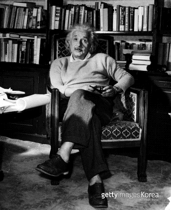 알베르트 아인슈타인이 1934년 파이프 담배를 손에 들고 의자에 앉아 있다. Photo by Lucien Aigner/Three Lions/Hulton Archive/Getty Images