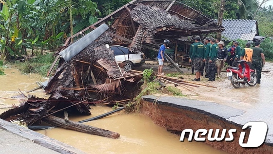 7일(현지시간) 태국 남부 나콘시탐마랏 주의 시촌에서 폭우로 야기된 도로 붕괴에 따른 피해 상황을 현지 관리들과 시민들이 점검하고 있다. © AFP=뉴스1