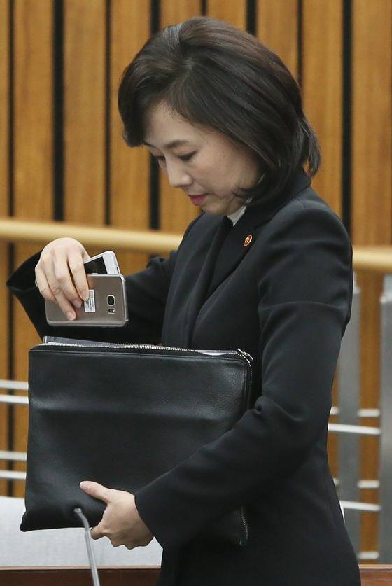 청문회 증인으로 출석한 조윤선 문화체육관광부장관이 9일 서울 여의도 국회에서 열린 박근혜 정부의 최순실 등 민간인에 의한 국정농단 의혹사건 진상규명을 위한 국정조사 특별위원회 청문회가 정회되자 청문회 장을 나서며 두 개의 휴대폰을 가방에 넣고 있다. 2017.1.9/사진=뉴스1