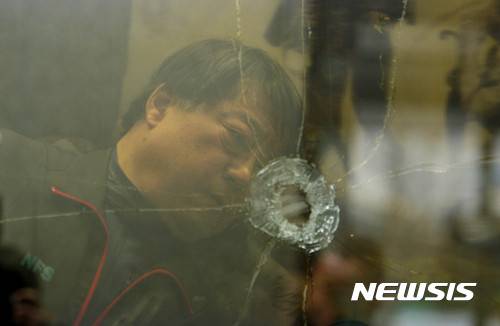 【광주=뉴시스】배동민 기자 = 국립과학수사연구원 법공학부 법안전과 김동환 총기연구실장이 17일 광주 동구 5·18민주화운동기록관에 옛 광주은행 본점 건물 유리창 3장의 탄흔 감식을 벌이고 있다. 2017.01.17. guggy@newsis.com