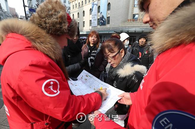 길을 묻는 외국관광객들에게 지도를 펼쳐 놓고 안내를 하고 있다. 신인섭 기자