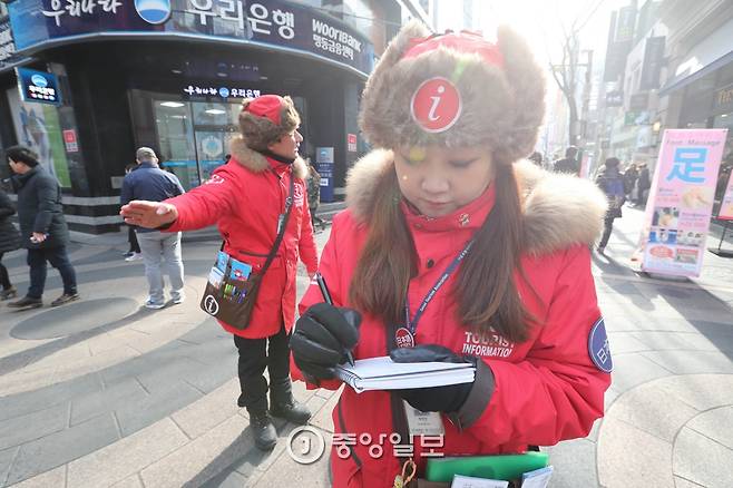 관광객의 질문에 답을 한 뒤 안내한 내용 등을 기록하고 있다. 신인섭 기자