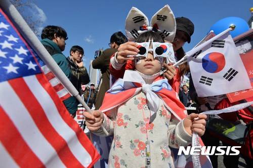 【서울=뉴시스】고승민 기자 = 대통령탄핵기각을위한국민총궐기운동본부가 25일 오후 서울광장과 대한문 앞에서 14차 탄핵반대 집회를 열고 있다. 부모 손에 이끌려 나온 어린이가 성조기를 흔들고 있다. 2017.02.25.   kkssmm99@newsis.com