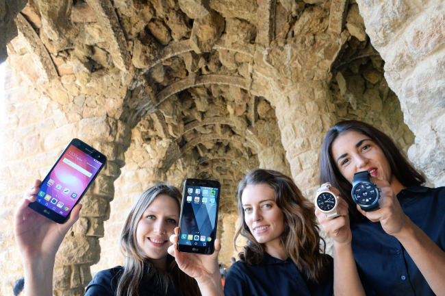 From left: Models showcase the LG X Power2, LG K10, LG Watch Style and LG Watch Sports, the company’s latest smart devices to be unveiled at the Mobile World Congress 2017, which kicks off in Barcelona, Spain, Monday. (LG Electronics)