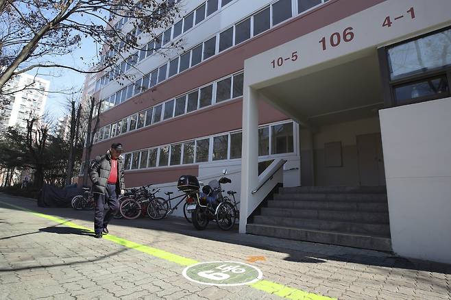 서울 노원구 SH공릉 1단지 아파트의 한 주민이 ‘치매도움 디자인’의 일환으로 보행로에 그려진 선을 따라 걷고 있다. 아파트 앞 바닥에는 동 번호가 적혀있다. [임현동 기자]