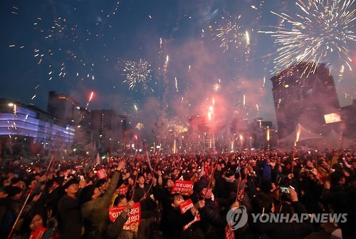 (서울=연합뉴스) 박동주 기자 = 11일 서울 광화문광장에서 열린 탄핵 환영 촛불집회에서 참가자들이 폭죽을 쏘아 올리고 있다. 2017.3.11      pdj6635@yna.co.kr