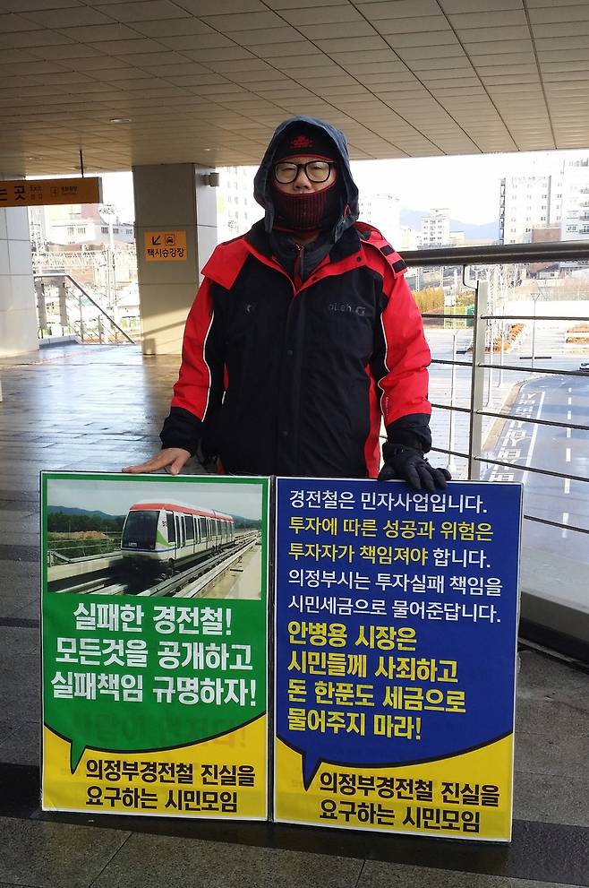 경기도 의정부지역 시민단체인 ‘의정부경전철 진실을 요구하는 시민모임’의 한 회원이 지난달 22일 의정부역 앞에서 의정부경전철 실패 책임 규명을 촉구하며 1인시위를 벌이고 있다. 의정부경전철 시민모임 제공