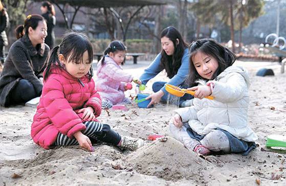 자녀의 발달단계·관심에 맞춰 놀이·체험을 중시하는 ‘적기교육’이 전업주부들 사이에서 관심을 받고 있다. 단순 주입식 조기교육을 시키기보다는 창의력·소통능력을 길러주려는 움직임이다. 13일 서울 목동의 한 놀이터에서 염미영(왼쪽)·진아영씨가 아이들과 놀아주고 있다. 평소엔 별다른 간섭 없이 지켜볼 뿐 아이들 놀이에 개입하지 않는다. [사진 김상선 기자]