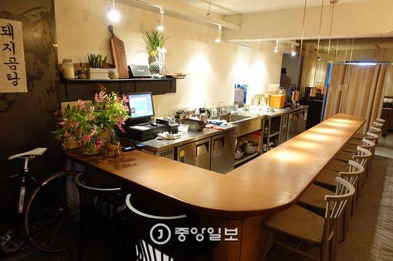 점심 영업이 끝나고 채 정리가 안 된 음식점 내부. 10명이 앉을 수 있는 바 형태의 식탁 안쪽은 주방이다. 식탁은 140장의 한지로 15겹을 바르고 옻칠로 마감했다.