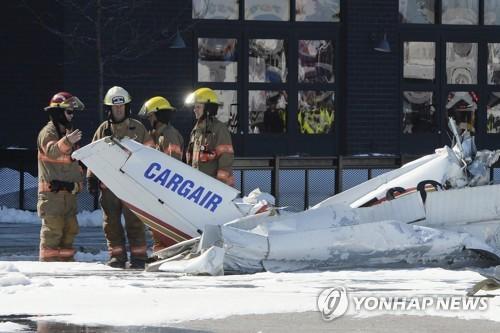 캐나다 퀘벡 주 생브루노 소방대원들이 17일 오후(현지시간) 공중 충돌 후 쇼핑몰 주차장에 추락한 항공기 잔해를 살펴보고 있다. [AP=연합뉴스]