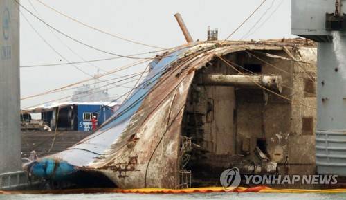 (진도=연합뉴스) 이진욱 기자 = 24일 오후 전남 진도군 사고 해역에서 세월호가 반잠수선으로 이동 준비하며 처참한 선수를 드러내고 있다.  cityboy@yna.co.kr