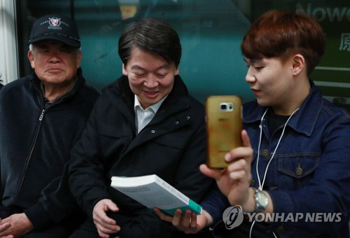 국민의당 안철수 후보가 지난 5일 새벽 지하철에서 시민을 만나 책을 선물받고 있다. (사진=연합뉴스)