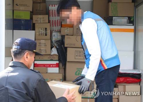 (서울=연합뉴스) 이상학 기자 = 정부가 경비원의 우체국 택배, 등기 대리수령을 가능하게 하는 입법을 추진한다. 20일 국토교통부와 미래창조과학부 우정사업본부에 따르면 우정사업본부는 작년 10월 우편법 시행령 개정안을 입법 예고했다. 이날 오후 서울시내 한 아파트 단지에서 경비원이 택배 물건을 수령하고 있다.   leesh@yna.co.kr