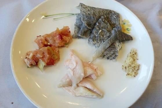 민어 코스 중 모둠접시에는 부레(흰색)·뼈다짐(붉은색)·껍질이 올라왔다. 오른쪽 가루는 깨소금이다.