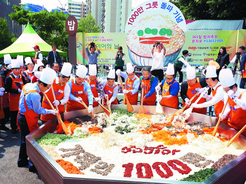 서울 동대문구 밥퍼나눔운동본부에서 2일 열린 ‘나눔잔치 오병이어의 날 행사’에서 최일도 목사(오른쪽 다섯 번째)등 참석자들이 1000인분 대형 비빔밥을 비비고 있다.