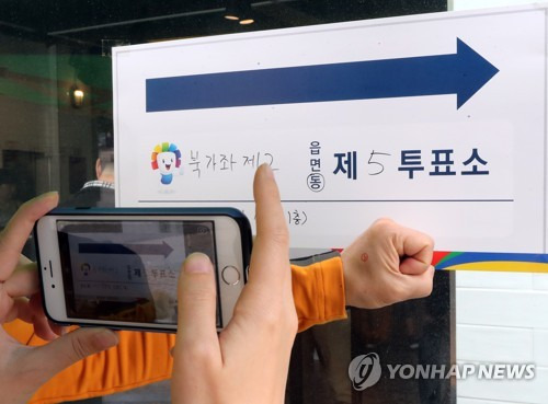 (서울=연합뉴스) 최재구 기자 = 제19대 대통령선거 투표일인 9일 서울 서대문구 북가좌 제2동 제5투표소에서 투표를 마친 시민들이 인증샷을 찍고 있다. 2017.5.9      jjaeck9@yna.co.kr