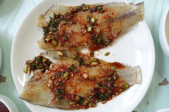 해물탕정식의 기본찬으로 나온 가자미찜. 생선을 반쯤 말렸다가 양념 발라 찌는 생선찜은 통영 스타일 반찬이다.