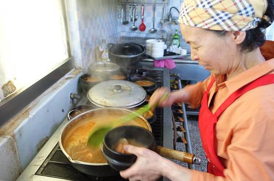 해물탕은 한꺼번에 끓여뒀다가 2인분씩 뚝배기에 나눠 담고 청홍고추·대파를 숭숭 썰어 넣고 한번 더 끓여서 상에 낸다. 탕을 준비하고 있는 ‘수봉식당’ 안주인 겸 주방장 김옥분씨. 한때는 마을 부녀회장을 맡기도 했다.