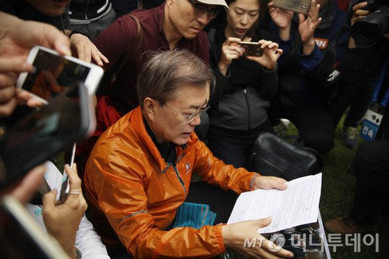 문재인 대통령이 당선 후 첫 주말인 13일 오전 기자들과 산행 전 청와대 경내에서 세월호 참사 미수습자 가족들이 보낸 편지를 읽고 있다. (청와대 제공)2017.5.13/뉴스1