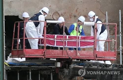 (목포=연합뉴스) 이정훈 기자 = 세월호 3층 선미 객실에서 온전한 형태로 수습된 유골이 관에 담겨 선체 밖으로 나오고 있다. 2017.5.23