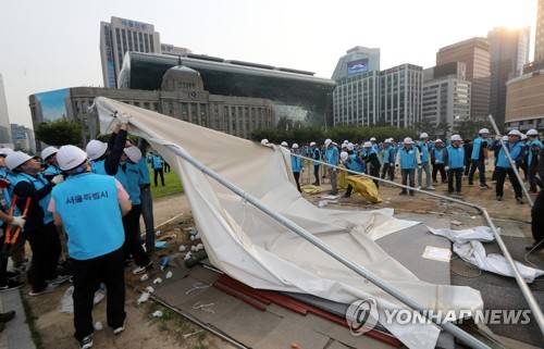 (서울=연합뉴스) 최재구 기자 = 30일 오전 시청 앞 서울광장에 설치된 보수단체 천막이 서울시 관계자들에 의해 강제 철거되고 있다. 서울광장 불법 텐트는 탄핵 국면인 올해 1월 21일 설치돼 넉 달 넘게 서울광장을 무단 점유해왔다.  2017.5.30      jjaeck9@yna.co.kr