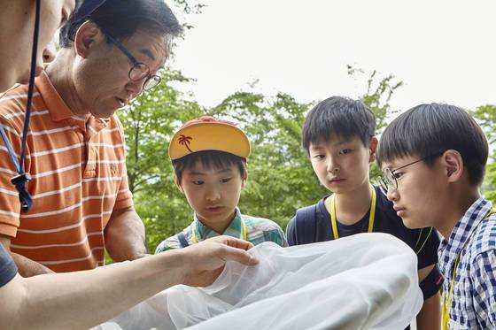 채집망으로 풀과 나무 근처를 훑으면 쉽게 곤충을 잡을 수 있다. 채집된 곤충을 살펴보는 소중 학생기자단.