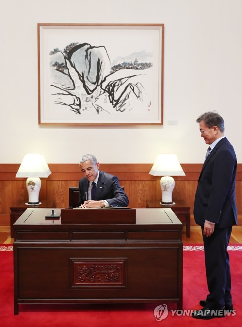 (서울=연합뉴스) 문재인 대통령이 3일 오후 청와대 본관에서 예방한 버락 오바마 전 미국 대통령의 방명록 작성을 바라보고 있다. 2017.7.3 [청와대 제공=연합뉴스]      photo@yna.co.kr