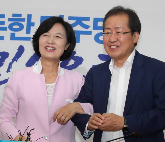 더불어민주당 추미애 대표가 4일 오후 국회 대표실을 방문한 자유한국당 홍준표 새 대표와 대화 도중 "우리가 서로 협치를 국민 앞에 약속한다는 의미에서 팔짱 한번 끼실까요?"라며 홍 대표와 팔짱을 끼고 있다. [연합뉴스]