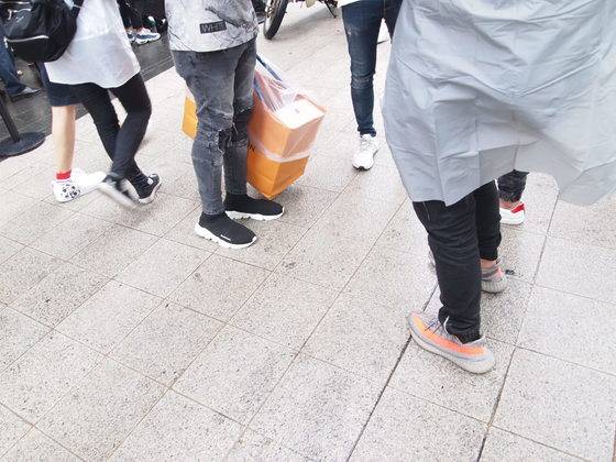 지난 7일에 포착한 청담동 루이비통 매장 앞. 루이비통 쇼핑백을 든 남성이 신은 신발이 발렌시아가 삭스 슈즈, 사진의 오른쪽 남성이 신은 제품이 아디다스 이지부스트다. 유지연 기자.