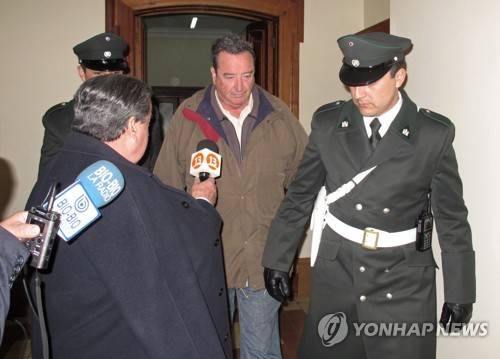 2013년 8월 오틸리오 로마노(가운데) 전 아르헨티나 연방법원 판사가 도피한 칠레 산티아고에서 신병인도 재판을 받고 나오는 모습. [AP=연합뉴스 자료 사진]