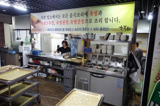 석이원 여주인이 주방에서 상을 보고 있다. 음식 간을 죽염으로 하고 고추장·된장·간장도 죽염제품을 사용한다는 현수막이 주방 앞에 걸려있다.