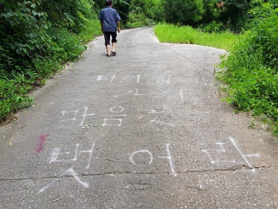 묘재마을 주민들이 누드 펜션 운영을 오르는 길에 항의 글을 써놨다. 최종권 기자